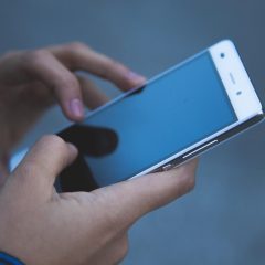 美高美技术编辑在双屏前检查页面排版的照片，屏幕上显示着卡片流版式与频道标签条